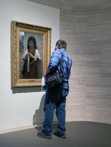 Michael Aaron Gallagher examines the brushstrokes of the oil painting “Tricoteuse (The Knitter)” (1879) by William-Adolphe Bouguereau, at the Appleton Museum of Art in Ocala, Florida.