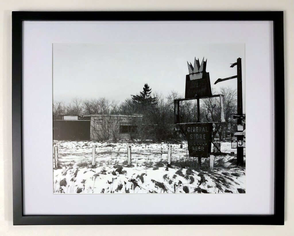 “You Can’t Go Home Again” (2021) by Michael Aaron Gallagher. The 11” x 14” photograph was taken at 16264 NY-12E in Dexter, NY. Built in 1962, I passed the general store and gas station on the corner many times as a child. Decades later, it is only a shadow of its former self, reminding me that you can never really go home.