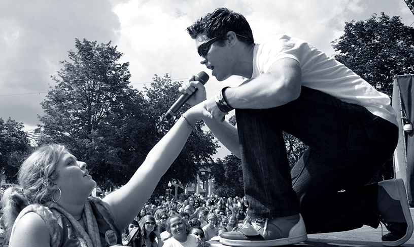 Canadian actor Drew Seeley, who was the singing voice of Troy Bolton in "High School Musical" and played alongside Selena Gomez in "Another Cinderella Story," serenades a fan at his concert. Photo by Michael Aaron Gallagher.